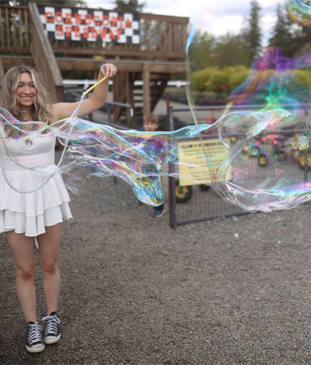 Woman Enjoying Making Bubbles At Bubble Station